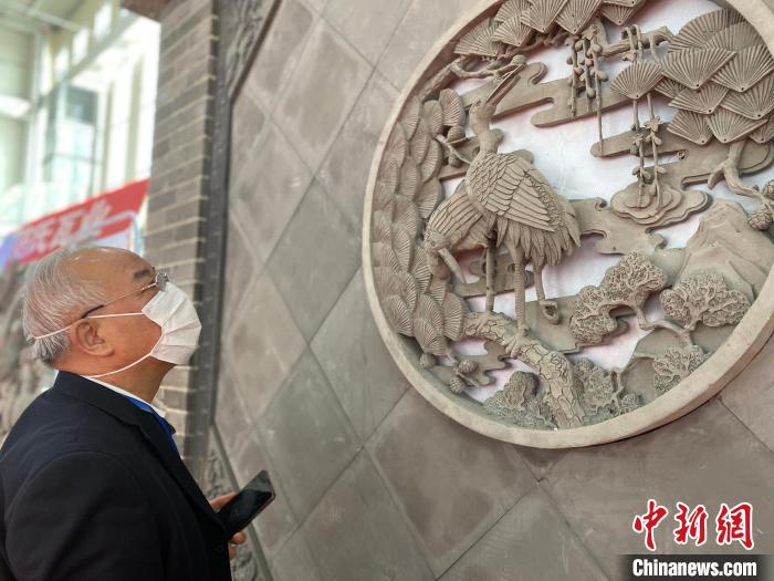 圖為2021邯鄲永年秋季房地產(chǎn)、家裝建材暨汽車博覽會(huì)上，一客戶在駐足觀看展出的磚雕產(chǎn)品。(資料圖) 趙明 攝