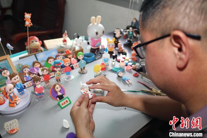 張小運用一雙巧手捏出一個個造型各異、栩栩如生的泥塑作品。　黃水林 攝