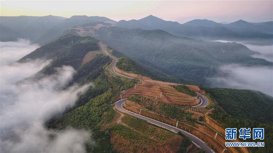 7月28日拍攝的鳳翅山至蟒頭山國家森林公園全域旅游示范路（無人機(jī)照片）。 位于陜西省延安市宜川縣鳳翅山至蟒頭山國家森林公園間的全域旅游示范路沿途風(fēng)景優(yōu)美，時(shí)常可見翻騰的云海。示范路方便旅客觀賞沿線叢林山水，也輻射帶動(dòng)了沿線3個(gè)貧困村的村民脫貧致富。 新華社發(fā)（趙潔 攝）