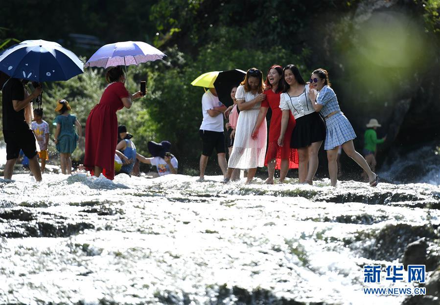 8月6日，游人在廣西柳州市鹿寨縣中渡鎮(zhèn)響水瀑布景區(qū)里戲水游玩（無(wú)人機(jī)照片）。 連日來(lái)，廣西柳州市持續(xù)高溫天氣，柳州市鹿寨縣中渡鎮(zhèn)響水瀑布景區(qū)成為人們休閑避暑的好去處，人們親水游玩，享受清涼。 新華社發(fā)（黎寒池 攝）