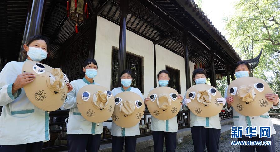8月12日，江蘇蘇州拙政園的幾名保潔員展示剛領(lǐng)到的太陽(yáng)能風(fēng)扇帽。 當(dāng)日，江蘇蘇州拙政園為一線保潔員、保安人員新添了太陽(yáng)能風(fēng)扇帽，防暑降溫送清涼，成為園內(nèi)一道別樣的風(fēng)景。 新華社發(fā)（杭興微 攝）