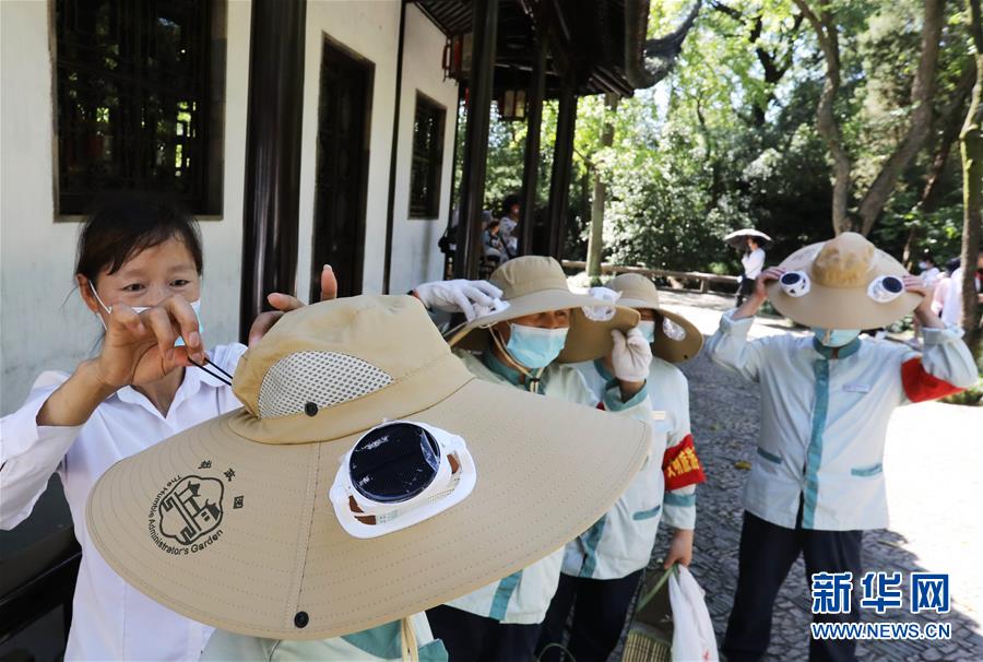 8月12日，江蘇蘇州拙政園的幾名保潔員戴上剛領(lǐng)到的太陽(yáng)能風(fēng)扇帽。 當(dāng)日，江蘇蘇州拙政園為一線保潔員、保安人員新添了太陽(yáng)能風(fēng)扇帽，防暑降溫送清涼，成為園內(nèi)一道別樣的風(fēng)景。 新華社發(fā)（杭興微 攝）