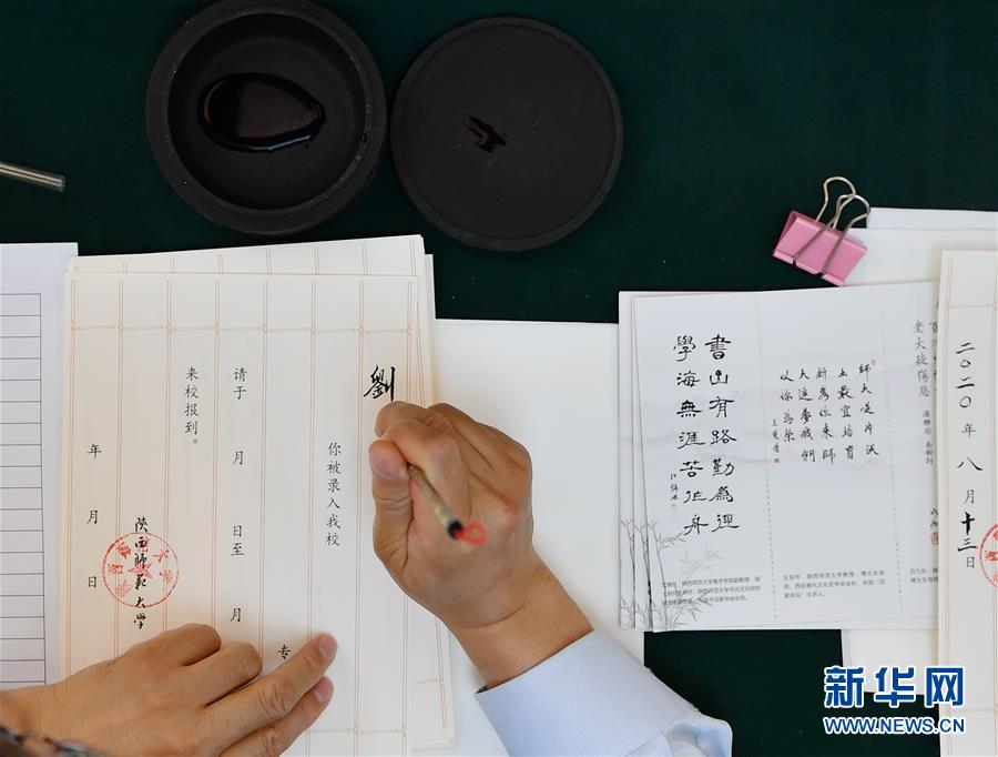 8月13日，陜西師范大學(xué)在職教師王雙懷書寫錄取通知書。 當(dāng)日，陜西師范大學(xué)2020年手寫錄取通知書正式開筆。該校自2007年起采用毛筆書寫錄取通知書的方式，為新生傳遞佳音。今年，學(xué)校十余位退休教師、在職教師、校友代表等書法愛好者將為約4500名新錄取的本科生送上帶著墨香的大學(xué)錄取通知書。 新華社記者 張博文 攝