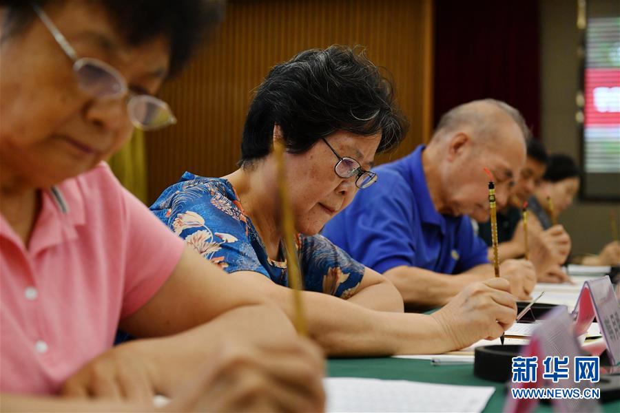 8月13日，陜西師范大學(xué)退休教師韓月娥（左二）等書寫錄取通知書。 當(dāng)日，陜西師范大學(xué)2020年手寫錄取通知書正式開筆。該校自2007年起采用毛筆書寫錄取通知書的方式，為新生傳遞佳音。今年，學(xué)校十余位退休教師、在職教師、校友代表等書法愛好者將為約4500名新錄取的本科生送上帶著墨香的大學(xué)錄取通知書。 新華社記者 張博文 攝