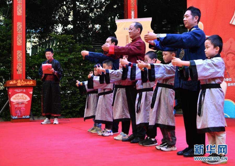 兩岸學(xué)子穿著傳統(tǒng)服飾向木偶戲傳承人行拜師禮后，一起向現(xiàn)場觀眾致意（11月21日攝）。新華社記者 魏培全 攝