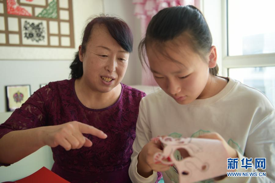 　　2月21日，在烏海市海南區(qū)新橋花園，李華（左）在家中指導(dǎo)外孫女高宇晨剪紙?！　〗衲?6歲的李華家住內(nèi)蒙古自治區(qū)烏海市海南區(qū)新橋花園，受長輩影響從小就開始剪紙。在李華引導(dǎo)下，她的大女兒譚紅葉也愛上了剪紙，經(jīng)常與李華探討創(chuàng)新剪紙技藝的想法。現(xiàn)在，李華的外孫女高宇晨也向她們學(xué)習(xí)剪紙技藝，已經(jīng)能獨(dú)立創(chuàng)作剪紙作品?！　±钊A堅(jiān)持剪紙40多年，創(chuàng)作了豐富的剪紙作品。為了傳承剪紙技藝，李華除了教授女兒、外孫女剪紙，還參加剪紙展覽、教學(xué)等活動，帶動更多的人學(xué)習(xí)、傳承剪紙技藝。　　今年春節(jié)，李華一家三代人一起剪紙，用不同的作品迎接新春?！拔蚁胪ㄟ^我們?nèi)说慕恿?，帶動親人朋友學(xué)習(xí)剪紙，讓剪紙技藝傳承下去?！崩钊A說?！　⌒氯A社記者 李志鵬 攝